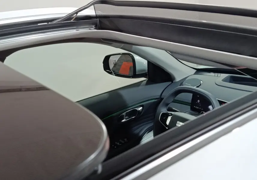 Vue intérieure côté conducteur d’un Geely Starray gris clair 2026 avec toit ouvrant et tableau de bord numérique.