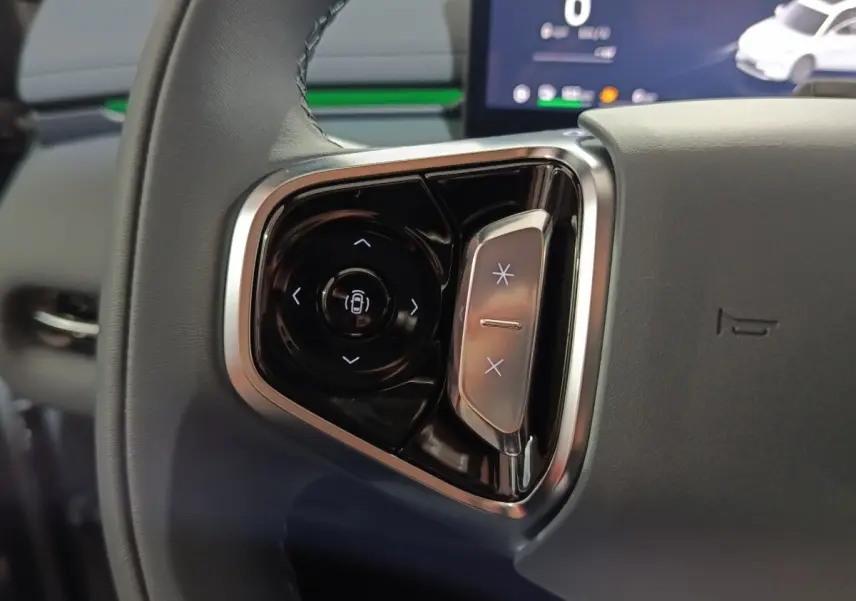 Gros plan sur les commandes multifonctions noires et argentées du volant gris du Geely STARRAY hybride rechargeable.