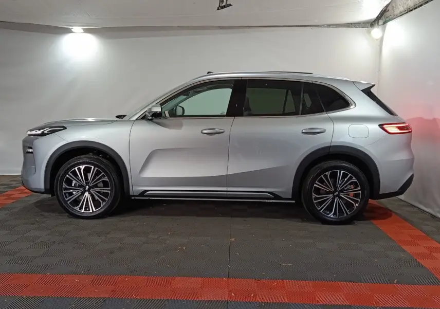 Vue latérale droite du SUV hybride rechargeable Geely STARRAY 1.5 EM-I PHEV Max+ gris clair dans un studio.