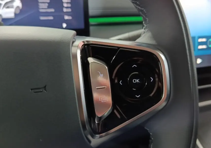 Gros plan sur les commandes multifonctions à droite du volant cuir noir du Geely STARRAY gris clair 2026.