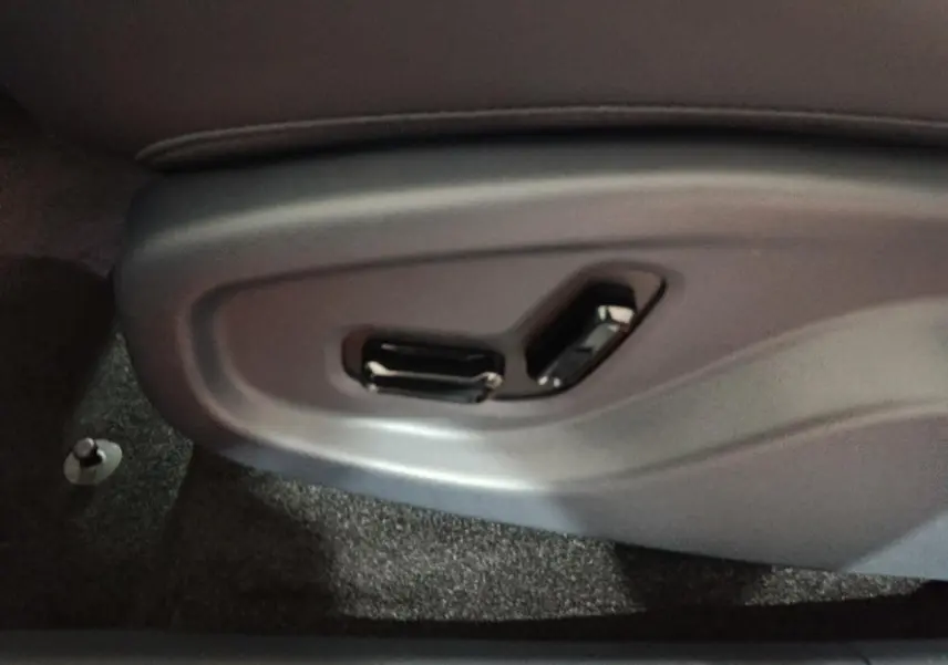 Gros plan sur les commandes électriques du siège côté conducteur du Geely STARRAY gris clair.