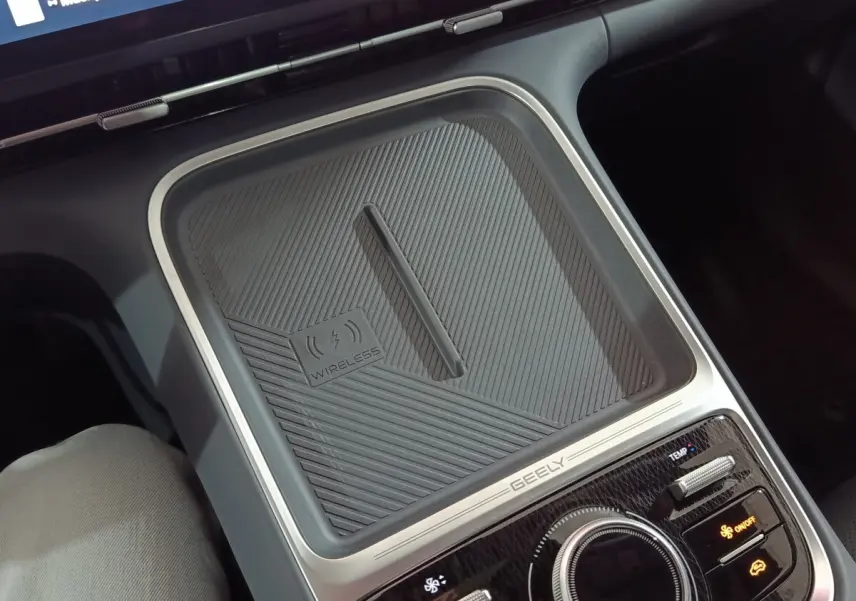 Vue rapprochée de la console centrale grise du Geely STARRAY 2026 avec zone de recharge sans fil et commandes climatisation.
