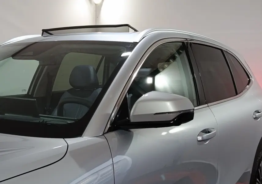 Vue de profil avant droit sur le Geely STARRAY gris clair avec toit ouvrant et rétroviseur intégré noir.