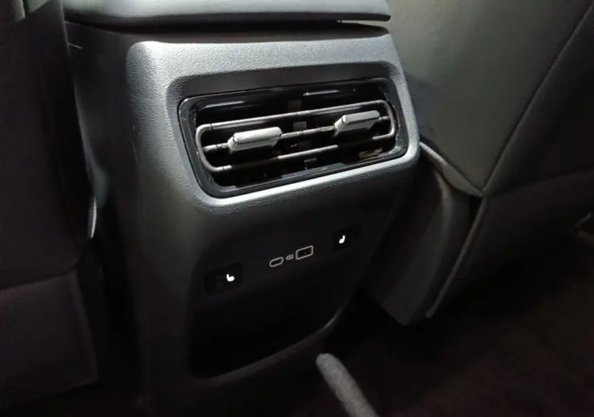 Vue rapprochée de la console arrière noire du GEELY STARRAY 1.5 EM-I PHEV Max+ avec aérateurs et ports USB.