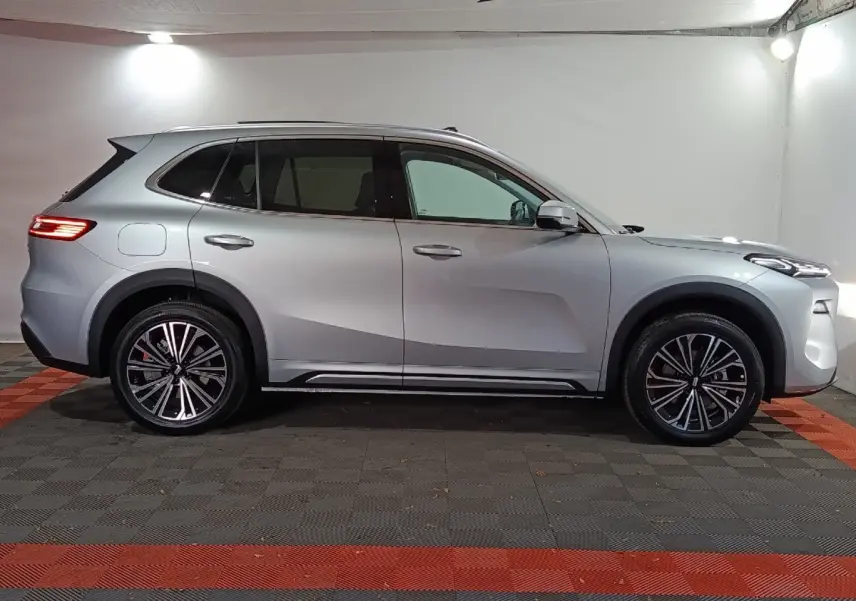 Vue de profil côté gauche d’un SUV Geely STARRAY gris clair 2026 avec jantes alliage et toit vitré.