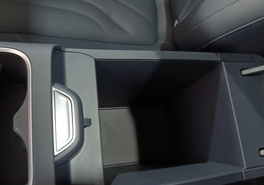 Vue rapprochée de l'accoudoir central arrière gris foncé du Geely STARRAY 1.5 EM-I PHEV Max+ avec rangement ouvert.