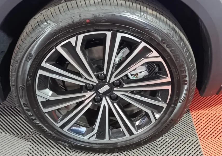 Gros plan sur la roue avant droite du Geely STARRAY gris clair, avec jante alliage noire et argentée au design moderne.