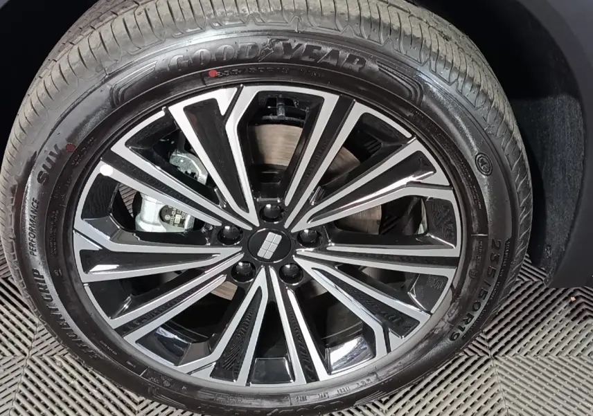 Gros plan sur la jante noire et argentée d’un Geely STARRAY gris clair, montrant le pneu Goodyear et le logo central.