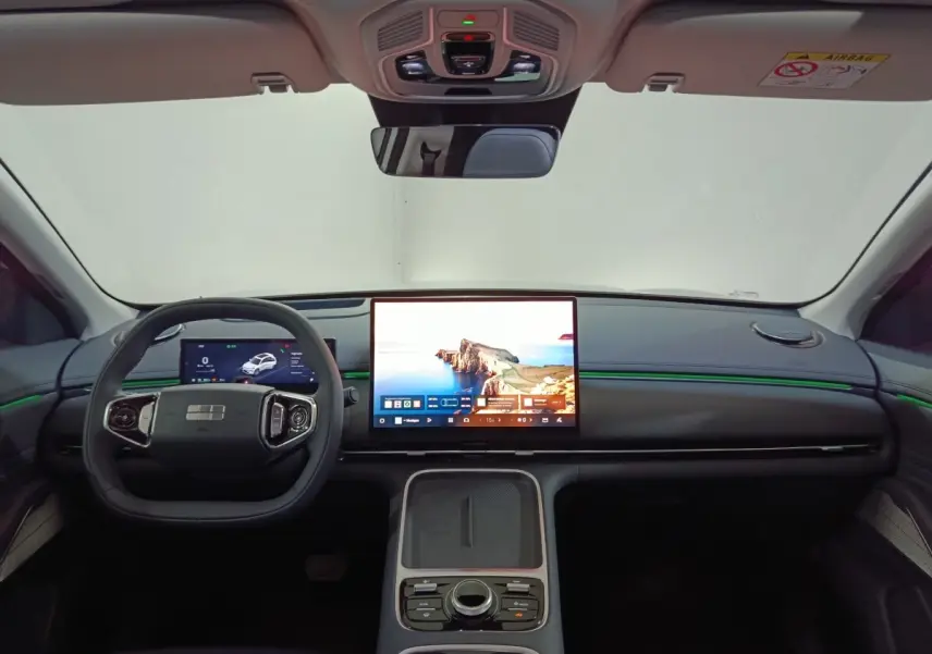 Vue frontale de l’habitacle du Geely STARRAY gris clair, avec grand écran tactile central et volant multifonctions.