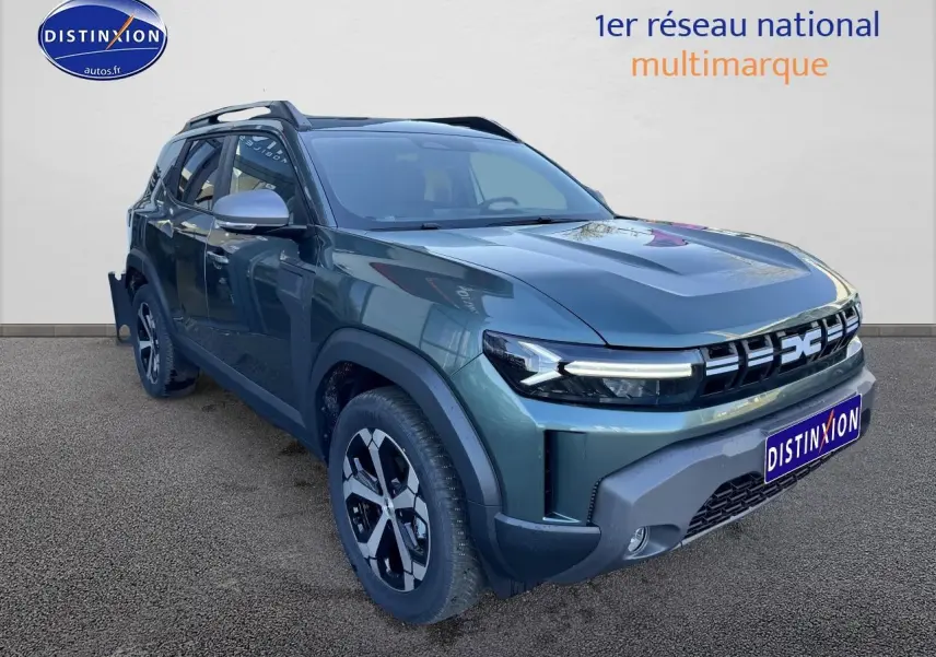 Vue 3/4 avant d'un Dacia Duster 2025 vert cèdre avec jantes alu et barres de toit visibles.