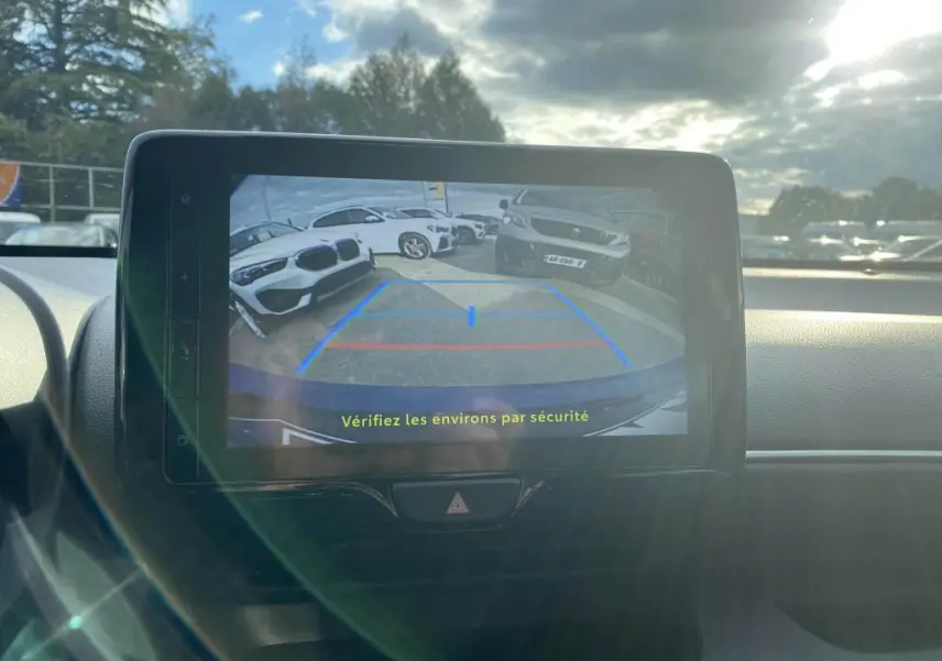 Écran tactile intérieur montrant la caméra de recul d'une Toyota Yaris hybride 2025, avec vue arrière sur un parking.