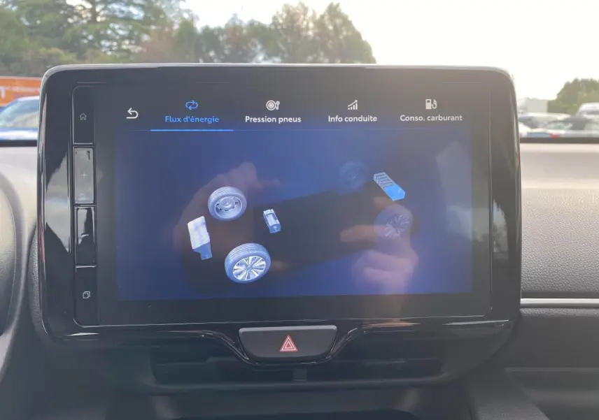 Écran tactile central de la Toyota Yaris 2025 montrant le flux d'énergie hybride, intérieur sobre et moderne.