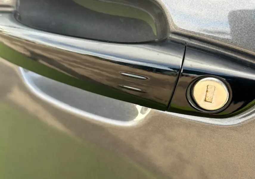 Poignée de porte noire brillante avec serrure sur la portière bleu eclipse métal du Citroën C5 Aircross 2025.