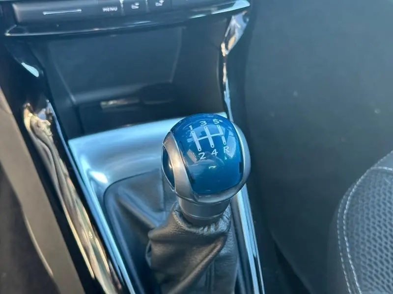 Gros plan sur le levier de vitesse manuel noir et argenté de la DS3 PureTech 110ch So Chic 2016, intérieur sombre.