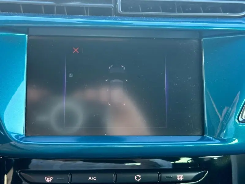 Écran tactile central bleu turquoise de la console d'une DS3 PureTech 2016, avec commandes climatisation visibles en dessous