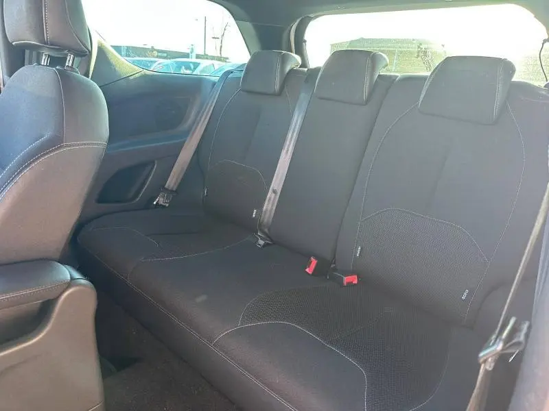 Vue intérieure sur la banquette arrière noire du DS3 2016 avec ceintures de sécurité et appuie-têtes intégrés.