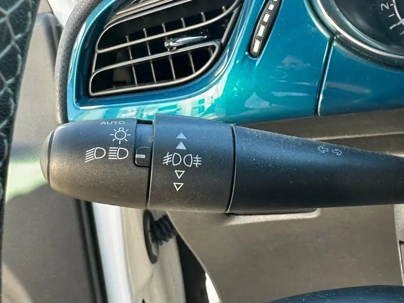 Gros plan sur la commande des phares et clignotants dans l'habitacle bleu d'une DS3 noire, version So Chic 2016.