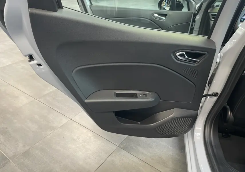 Vue rapprochée de la porte arrière gauche gris Rafale de la Renault Clio 1.5 Blue dCi 2025 avec commande de fenêtre.