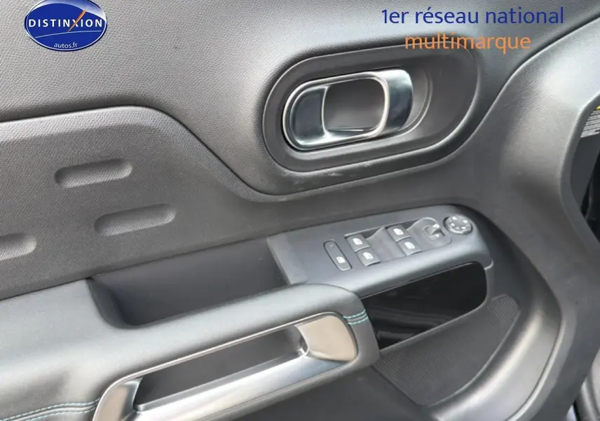 Gros plan sur la porte avant gauche noire du Citroën C5 Aircross avec commandes des vitres et poignée chromée.
