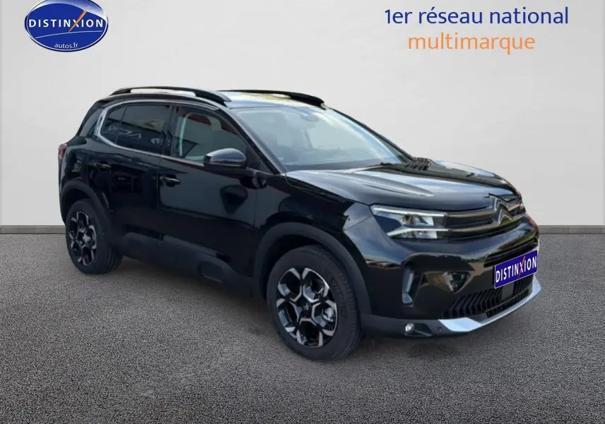 Citroën C5 Aircross noir perla nera en 3/4 avant droit avec barres de toit et jantes alu distinctives.
