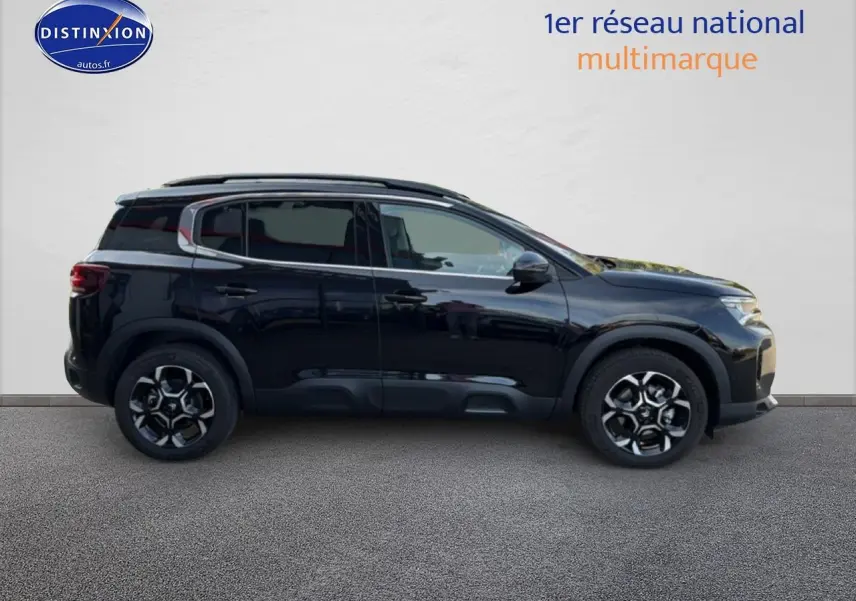 Profil droit du SUV Citroën C5 Aircross noir Perla Nera 2025 avec jantes alu et barres de toit visibles.