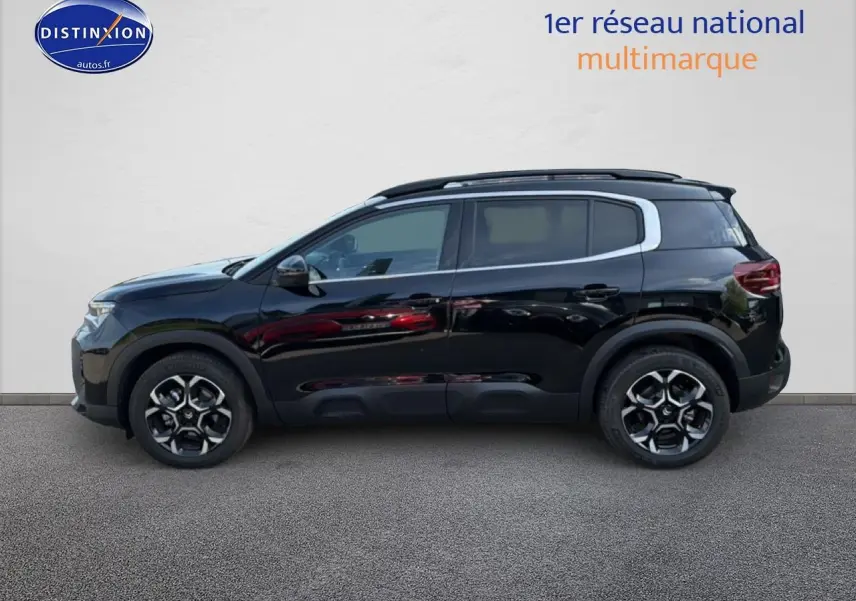 Profil côté gauche du SUV Citroën C5 Aircross noir Perla Nera avec jantes alu et barres de toit visibles.