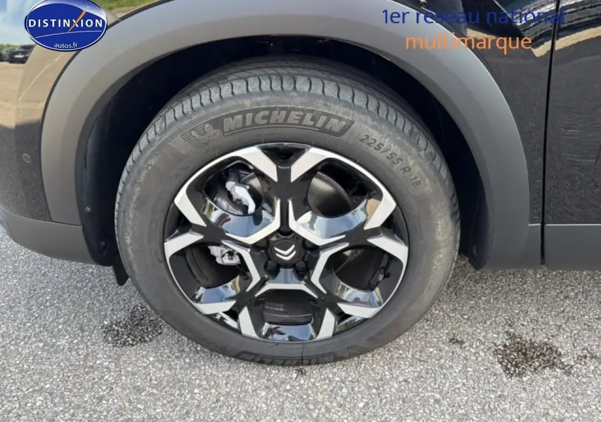 Gros plan sur la roue avant gauche du Citroën C5 Aircross noir Perla Nera avec jante alliage bicolore et pneu Michelin.