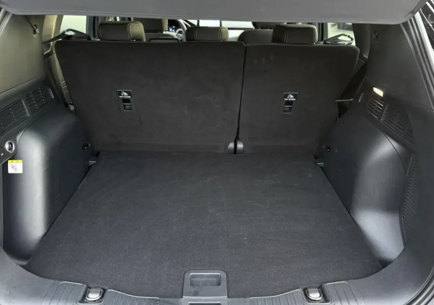 Coffre spacieux du Ford Kuga 2024 noir Obsidien, vue arrière avec banquette arrière relevée et plancher plat.