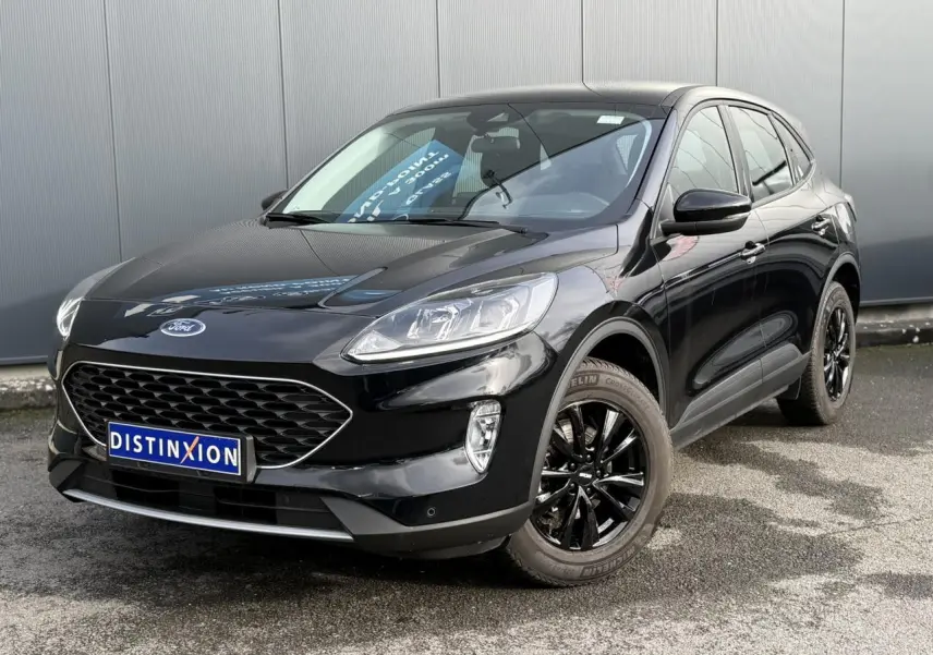 Ford Kuga 2024 noir obsidien en 3/4 avant droit avec jantes alliage noires et attelage rétractable visible.