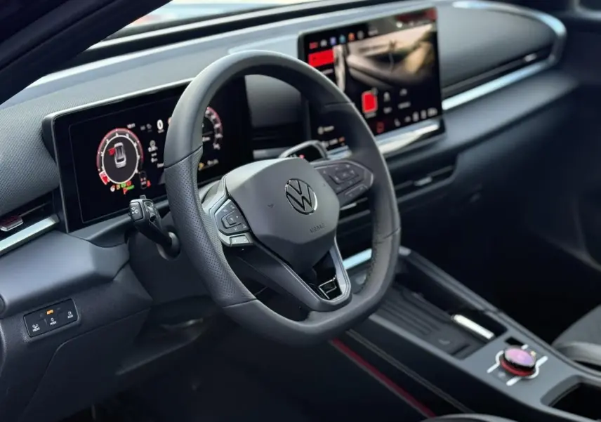 Vue intérieure du tableau de bord et volant noir du Volkswagen T-Roc 2026 avec écran digital et console centrale moderne.
