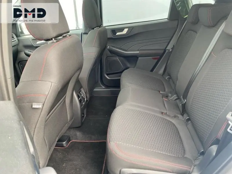 Vue intérieure arrière côté droit du Ford Kuga 2026, sièges tissu noir avec surpiqûres rouges et ceintures de sécurité.