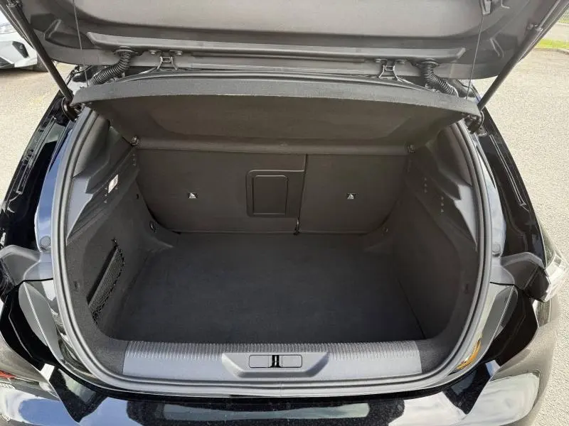 Coffre ouvert vu de l'arrière d'une Peugeot 308 noir Perla Nera, montrant un espace de chargement propre et spacieux.