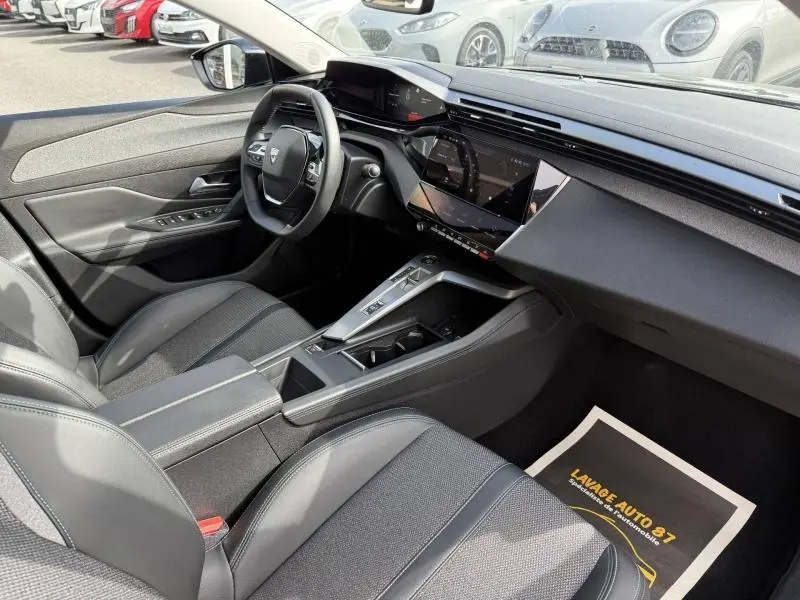 Vue intérieure côté conducteur de la Peugeot 308 2024 en Noir Perla Nera, avec tableau de bord digital et console centrale moderne.