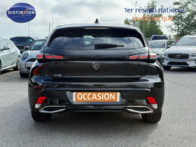 Vue arrière d'une Peugeot 308 noire Perla Nera avec feux LED distinctifs et double sortie d'échappement chromée.