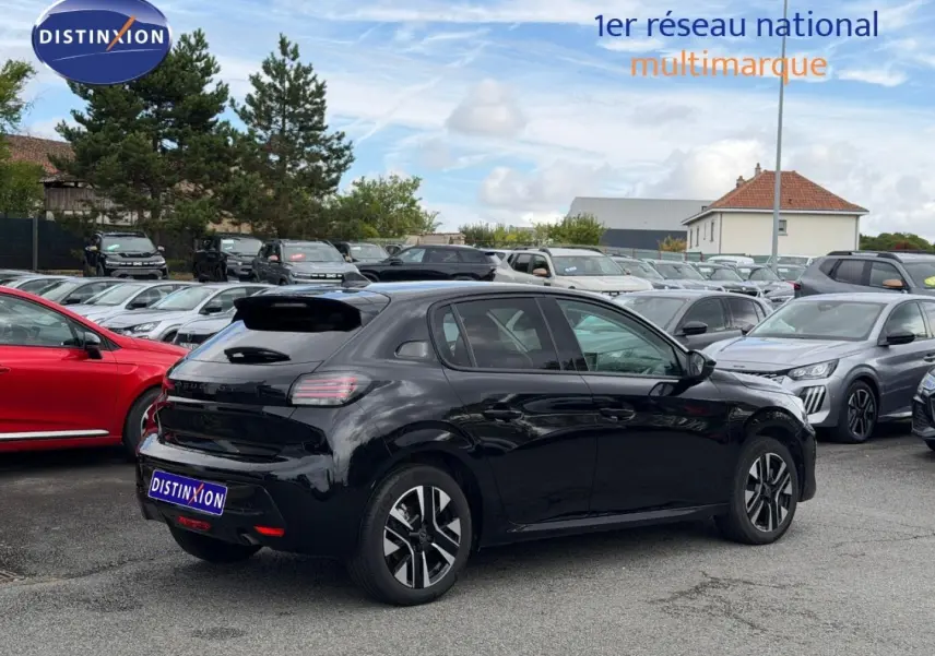 Peugeot 208 noir Perla Nera vue 3/4 arrière droit, jantes alu et vitres teintées en extérieur parking.