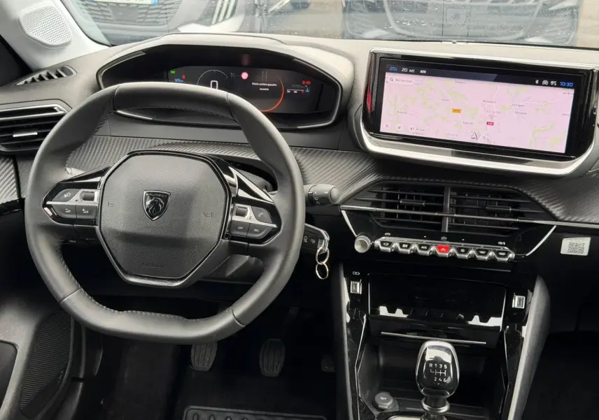 Intérieur Peugeot 208 1.2 100ch noir, vue du poste de conduite avec volant compact et écran tactile central.