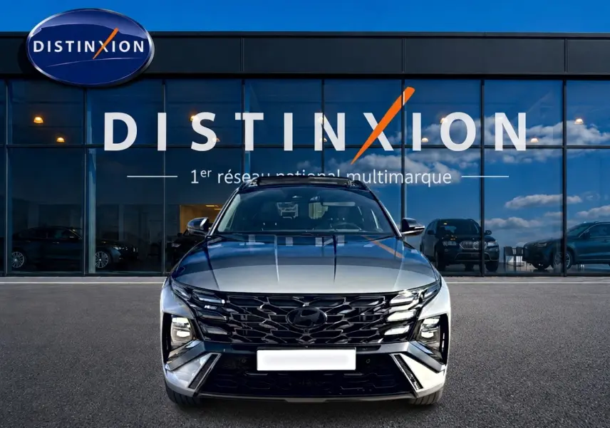 Vue avant d'un Hyundai Tucson 1.6 t-gdi hybride gris shadow avec calandre noire et phares LED distinctifs.