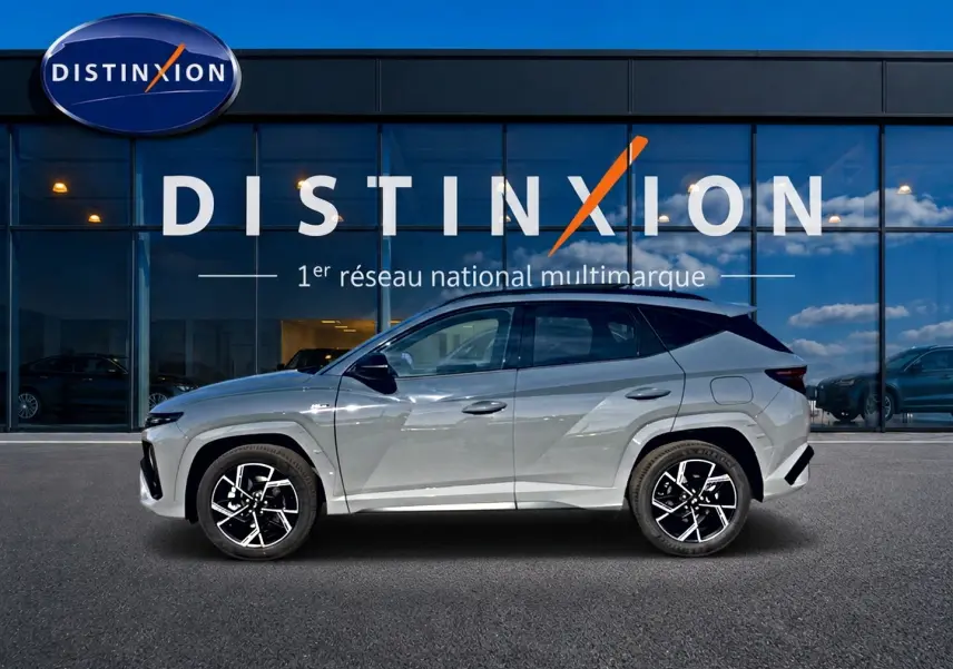 Hyundai Tucson 2026 gris shadow en profil droit, avec jantes alu noires et toit panoramique visible.