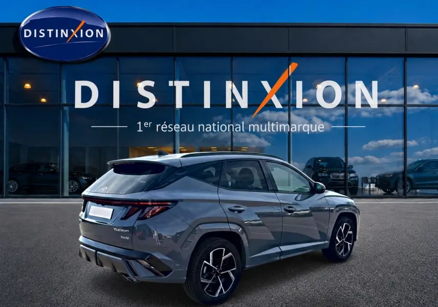 Vue 3/4 arrière droite d’un Hyundai Tucson 1.6 t-gdi hybride en gris shadow avec jantes alu et feux LED distinctifs.