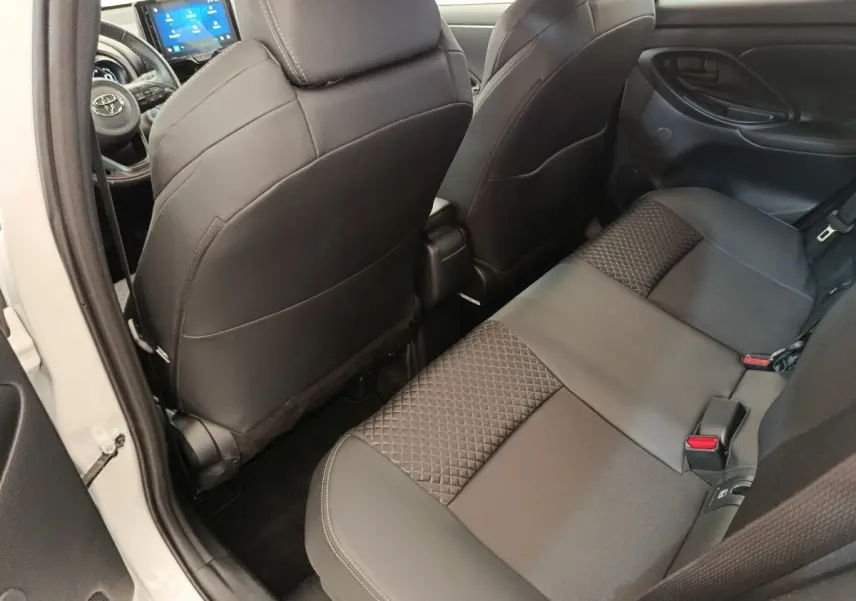 Vue intérieure arrière côté gauche de la Toyota Yaris Hybride 116h Collection 2022, sièges noirs avec motifs géométriques.