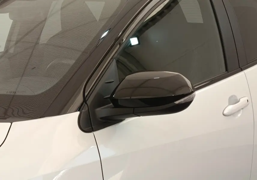 Vue rapprochée du rétroviseur noir côté conducteur sur la porte blanche d’une Toyota Yaris Hybride 2022.