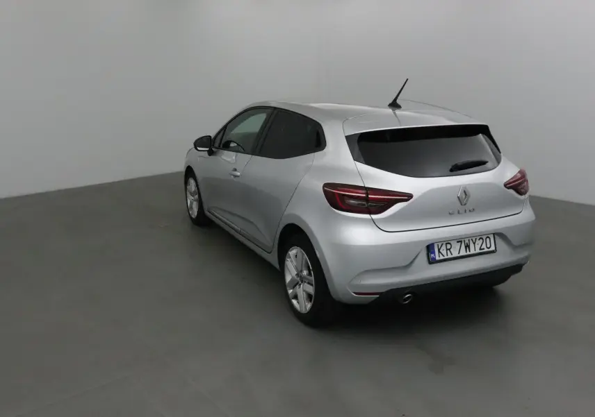 Renault Clio V gris platine vue 3/4 arrière droit dans un studio, feux arrière LED et vitres teintées visibles.