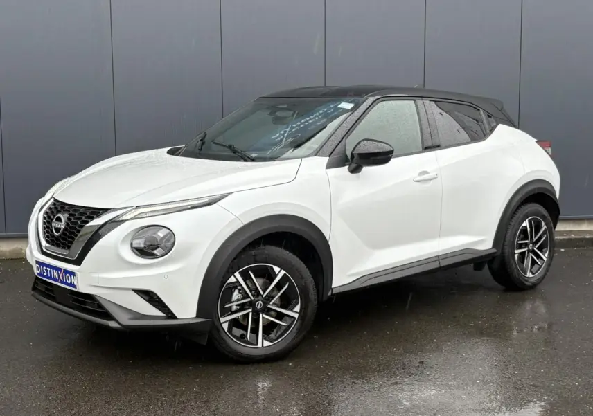 Nissan Juke blanc nacré en 3/4 avant droit avec toit noir et jantes alliage 17 pouces.