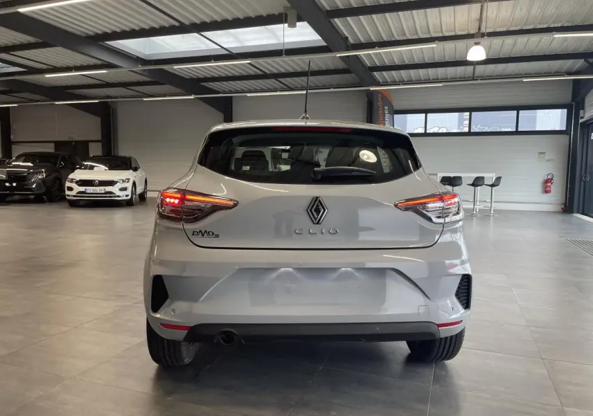 Vue arrière d'une Renault Clio 1.5 Blue dCi 2025 gris Rafale avec feux LED allumés dans un showroom.