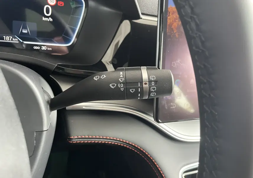 Gros plan sur la manette d’essuie-glace côté droit du tableau de bord du BYD SEAL U 2025, intérieur noir avec surpiqûres rouges.