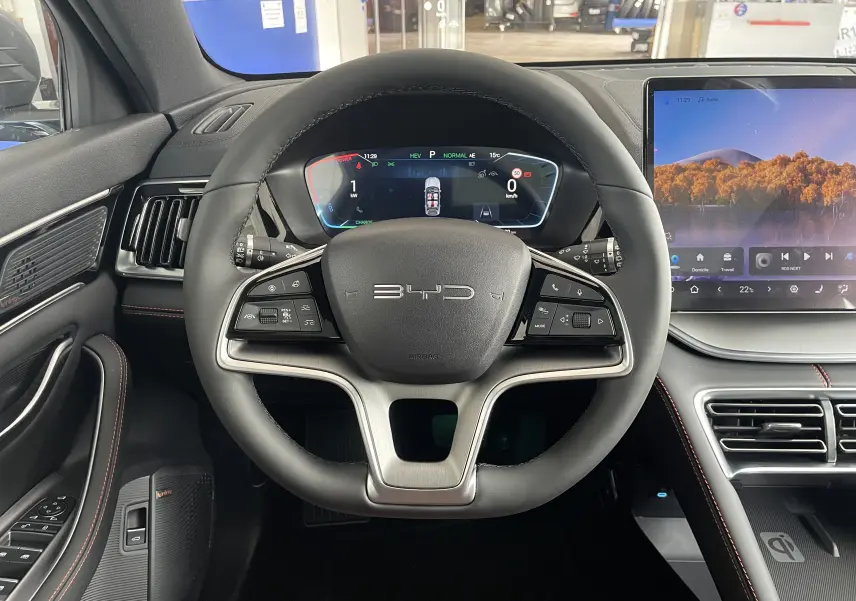 Vue centrée sur le volant noir du BYD SEAL U avec tableau de bord numérique et écran tactile latéral.