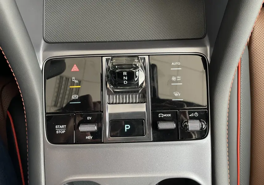 Gros plan sur la console centrale grise du BYD SEAL U avec levier de vitesses cristal et commandes tactiles.