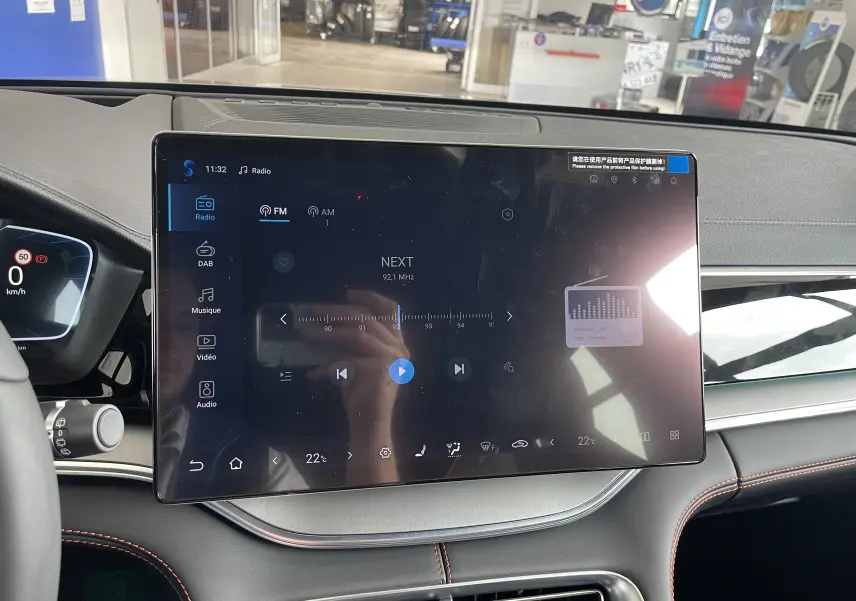 Vue rapprochée de l’écran tactile central 15,6’’ du tableau de bord du BYD SEAL U, intérieur noir avec surpiqûres rouges.