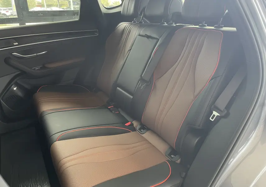 Vue latérale droite des sièges arrière en similicuir noir et marron avec surpiqûres rouges du BYD SEAL U 2025 Time Grey.