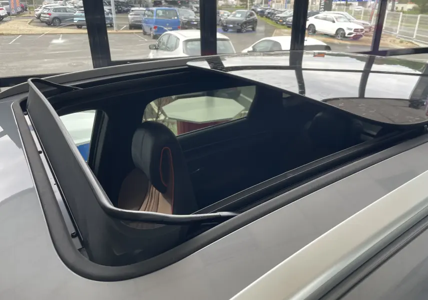 Vue en plongée du toit ouvrant panoramique ouvert du BYD SEAL U gris Time Grey, montrant l'intérieur avec sièges noirs et détails rouges.